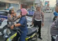 Satuan Lalu Lintas Polres Bitung melakukan kegiatan pembagian helm gratis kepada warga masyarakat pengendara sepeda motor yang melintas di jalan, Sabtu (13/9/2025).