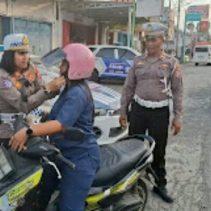Satuan Lalu Lintas Polres Bitung melakukan kegiatan pembagian helm gratis kepada warga masyarakat pengendara sepeda motor yang melintas di jalan, Sabtu (13/9/2025).